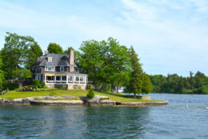 St Lawrence River's Thousand Islands, Canada and United States of America- June 19, 2016- Island with house, cottage or villa in Thousand Islands Region in sunny summer day in Kingston, Ontario, Canada. 1000 Islands near Gananoque, ON. Canadian vacation