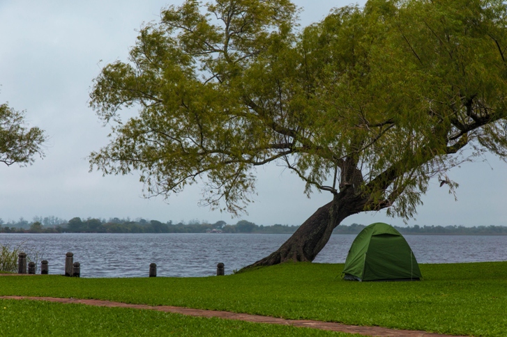 green camping tent beside the lake
